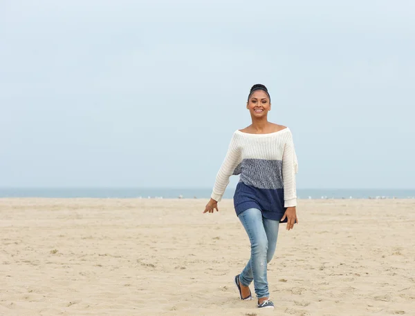 Vrolijke jonge vrouw lopen op een strand — Stockfoto