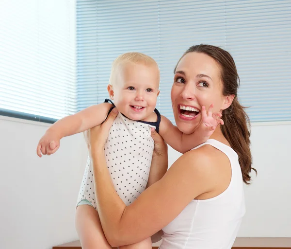 Glad mamma leker med söta leende barnet hemma — Stockfoto