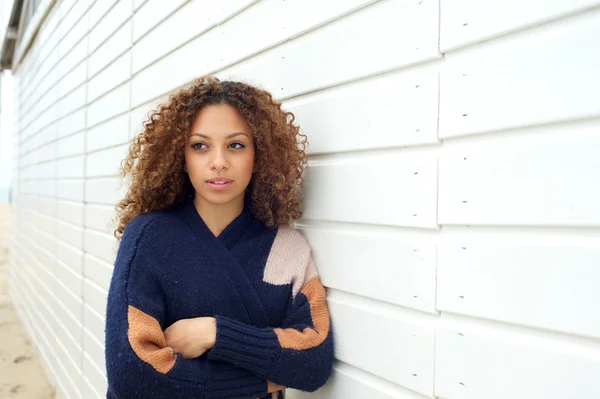 Belle jeune femme aux cheveux bouclés et pull posant à l'extérieur — Photo