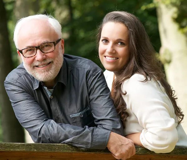 Reifer Vater und kleine Tochter lächeln draußen — Stockfoto