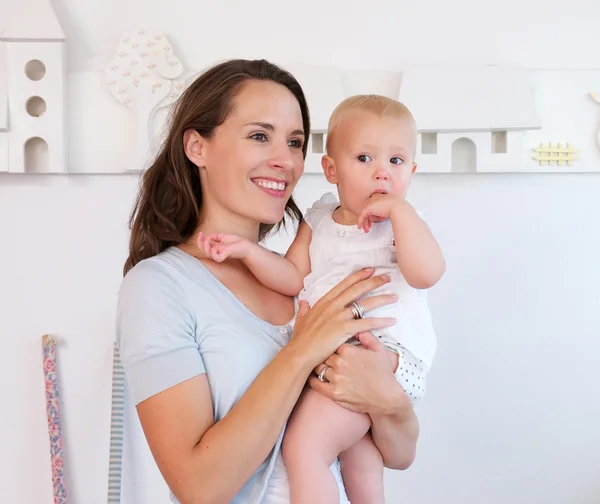 Beautiful mother holding cute baby indoors — Stock Photo, Image