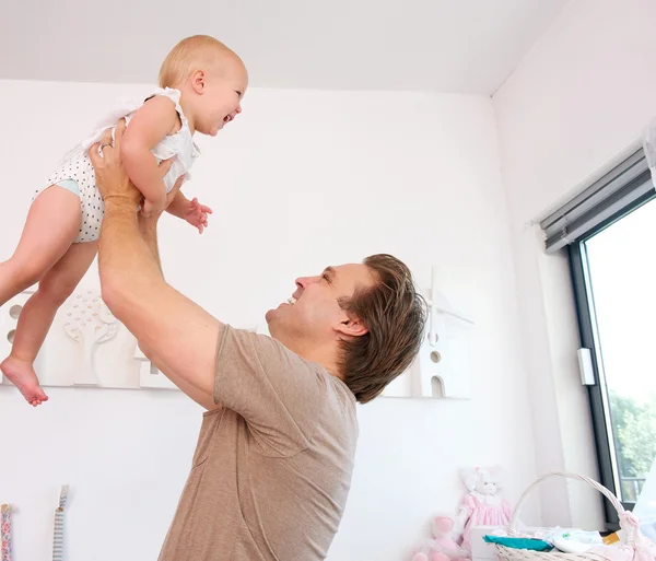 Retrato de un padre amoroso levantando y jugando con un bebé lindo —  Fotos de Stock
