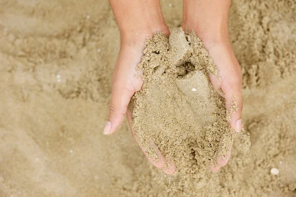 Zwei Hände, die Sandkörner halten — Stockfoto