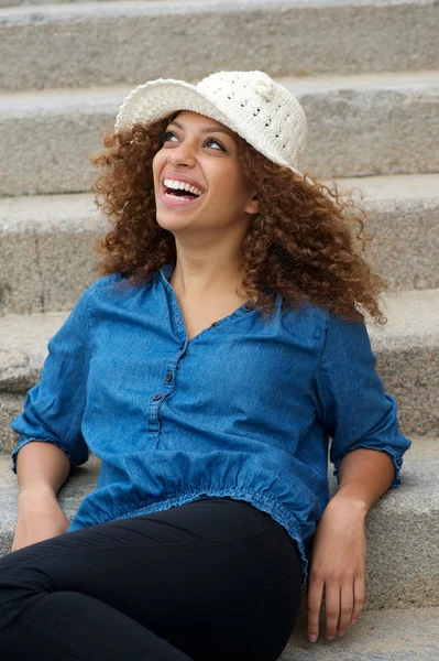 Счастливая женщина сидит на улице и смеется — стоковое фото