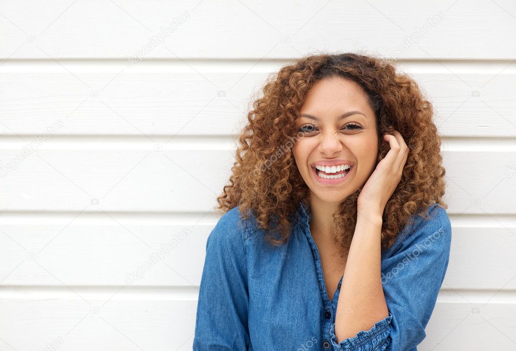 Portrait of a beautiful woman laughing with hand in hair