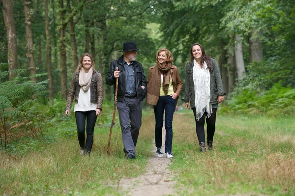 Lycklig familj njuter av en promenad i skogen — Stockfoto