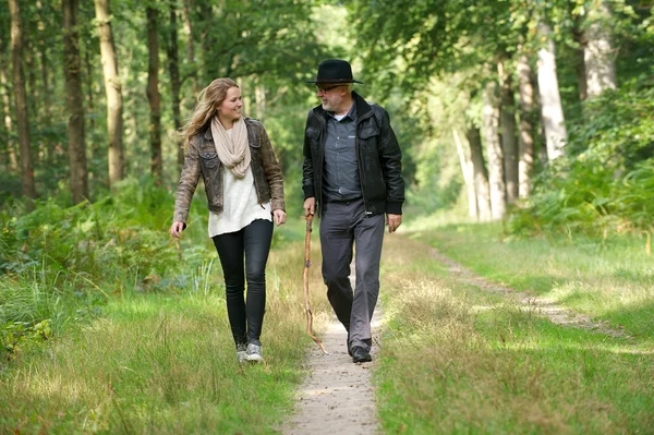 Pai e filha sorrindo e andando na natureza — Fotografia de Stock