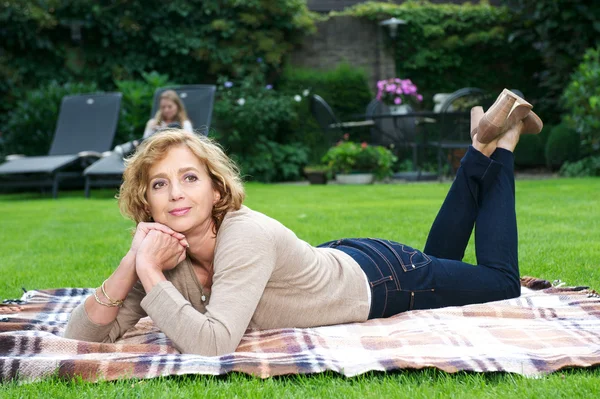 Mulher madura atraente relaxando no jardim — Fotografia de Stock