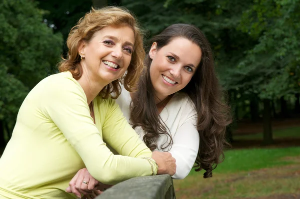 Portret van een gelukkige moeder en dochter glimlachend buitenshuis — Stockfoto