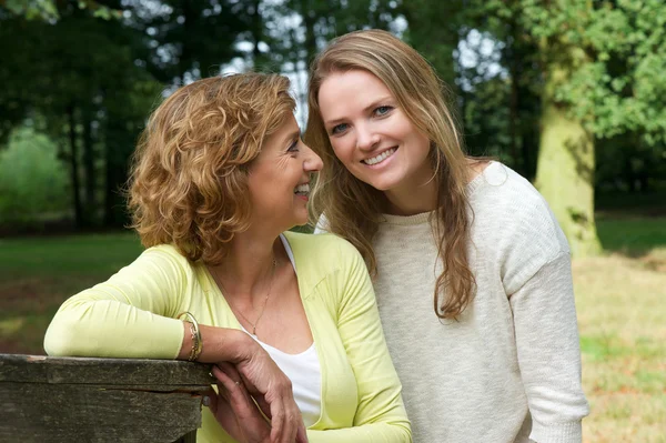 Portrait of mother and daughter smiling outdoors Stock Picture