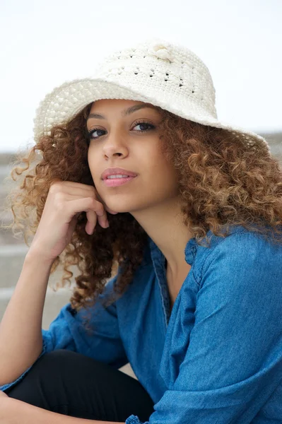 Portrét atraktivní mladá žena seděla venku s kloboukem — Stock fotografie