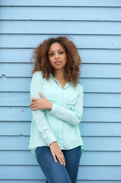 Junge Frau steht draußen vor blauem Hintergrund — Stockfoto