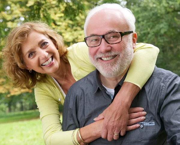 Retrato de um casal de idosos felizes sorrindo ao ar livre — Fotografia de Stock