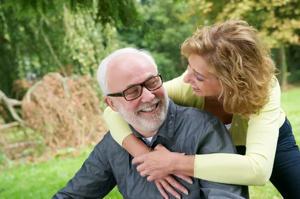 Oudere man en vrouw die lacht buitenshuis — Stockfoto