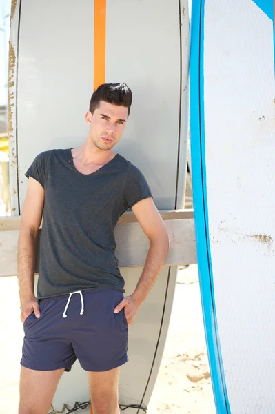 Männermode-Model steht mit Surfbrettern im Freien — Stockfoto