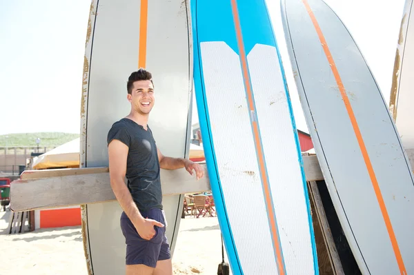 Portret szczęśliwy człowiek stojący na plaży z desek surfingowych — Zdjęcie stockowe