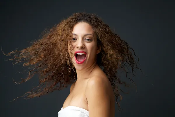 Portrait of a beautiful young woman with blowing hair laughing — Stock Photo, Image