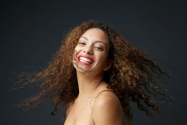 Portrait of a young woman smiling with curly hair — Stock Photo, Image