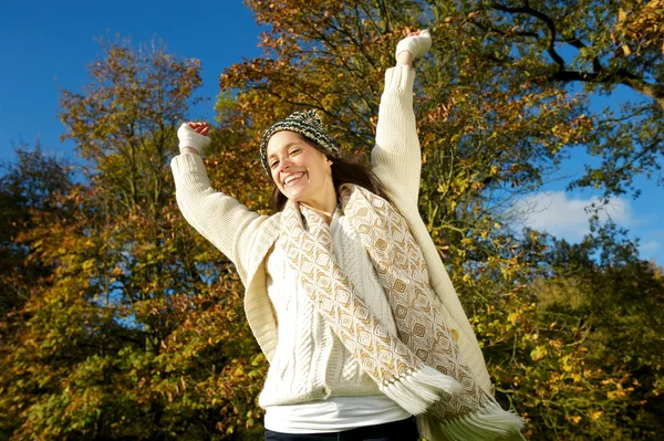 Beautiful young woman smiling outdoors with arms outstretched — Stock Photo, Image