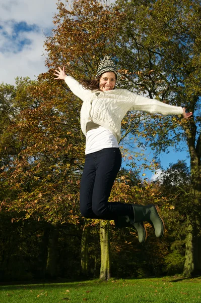 Jovem mulher excitada pulando fora em um belo dia de outono — Fotografia de Stock