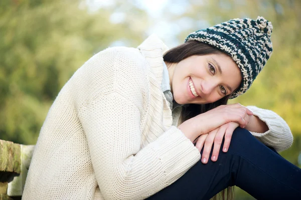 Açık havada kazak ve şapka ile gülümseyen güzel genç kadın — Stok fotoğraf