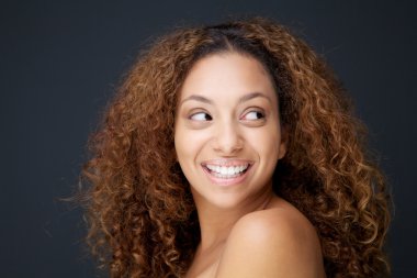 güzel bir genç kadın kıvırcık saçlı gülen ve uzağa arıyorsunuz