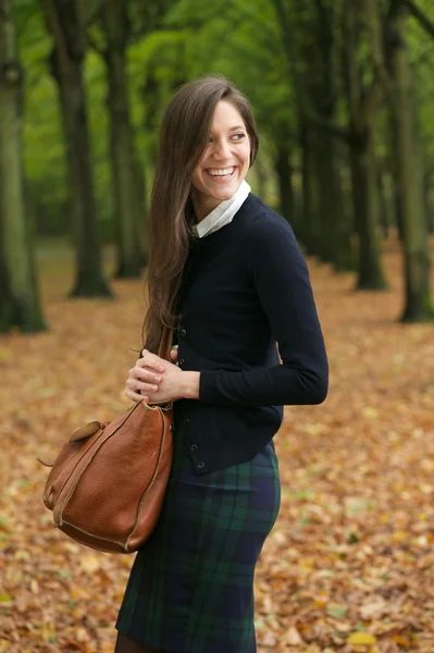 Mujer joven feliz riendo y caminando al aire libre con bolsa —  Fotos de Stock