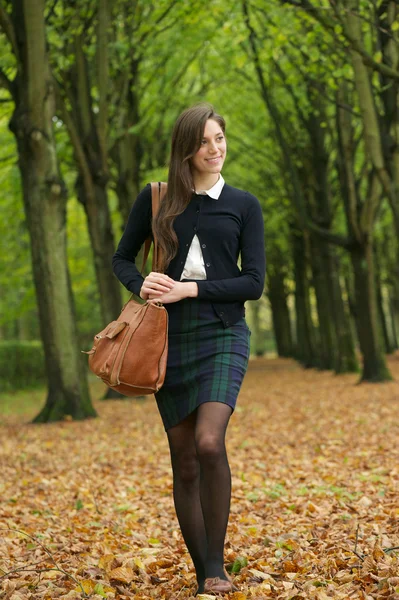 Young woman walking in the park on an autumn day — Stock Photo, Image