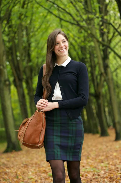 Une jeune femme souriante marche dans le parc un jour d'automne — Photo