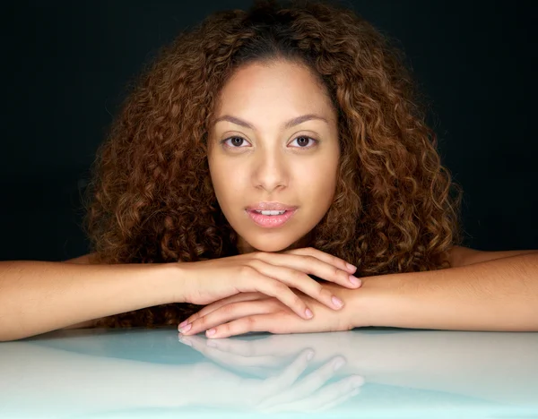 Portrait of a beautiful young woman with curly hair looking at camera — Stock Photo, Image