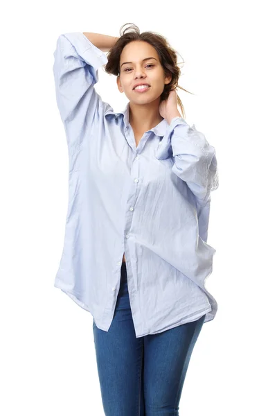 Молодая женщина в удобной рубашке и джинсах улыбается с руками в волосах — стоковое фото