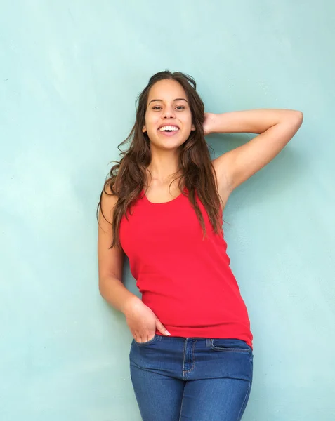 Mujer joven con camisa roja sonriendo con la mano en el pelo — Foto de Stock