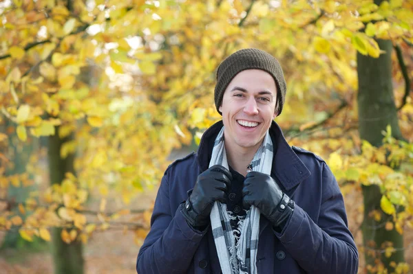 Portrait of a happy man in jacket scarf gloves hat smiling outdoors in autumn — Stock Photo, Image