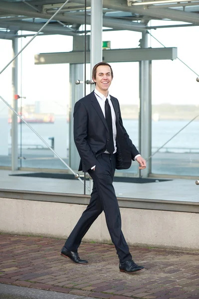 Portret van een knappe jonge zakenman wandelen in de stad — Stockfoto