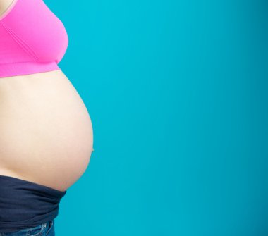 hamile kadın mide mavi zemin üzerine yan Görünümü Kapat