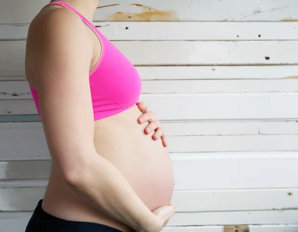 Young woman holding pregnant stomach — Stock Photo, Image