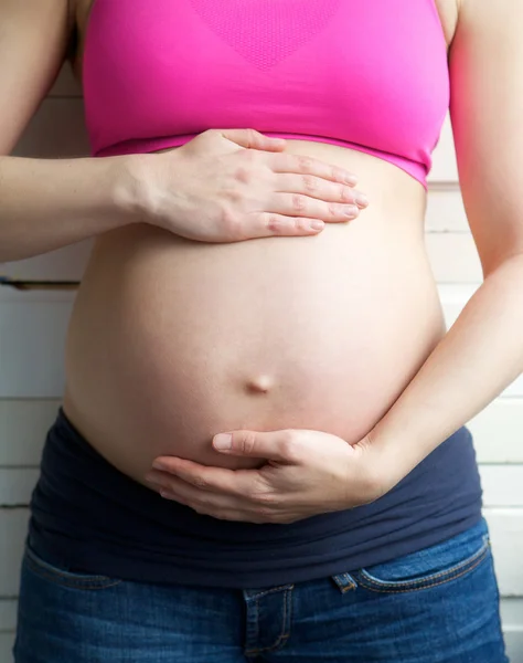 Female holding pregnant stomach — Stock Photo, Image