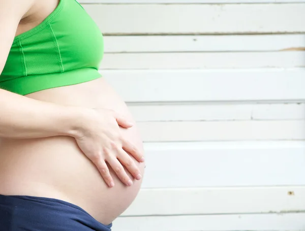 Close up portrait of woman touching pregnant stomach — Stock Photo, Image