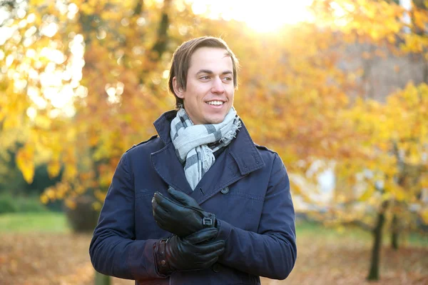 Portret van een glimlachende man buiten op een daling dag — Stockfoto