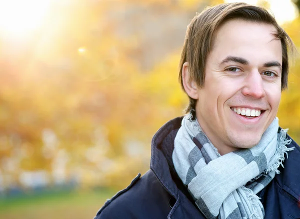 Portret młodego mężczyzny uśmiechający się stojący na zewnątrz — Stockfoto