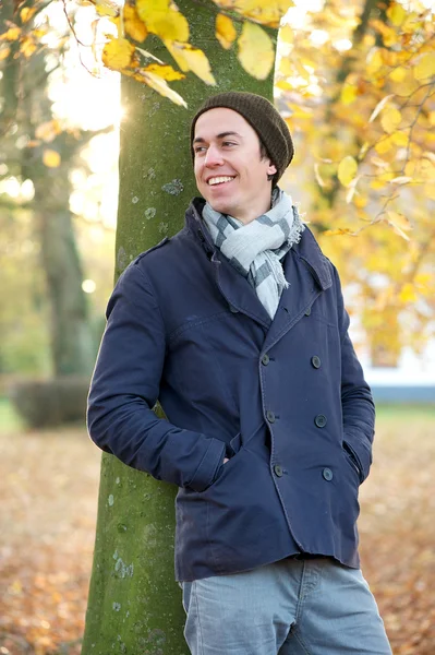 Handsome young man smiling outdoors on a fall day — Stock Photo, Image