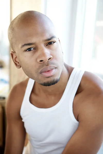 Portrait of a handsome young man sitting alone indoors — Stock Photo, Image