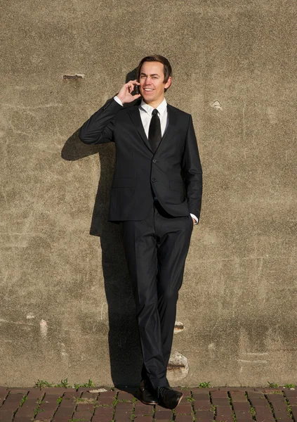 Happy business man relaxing outdoors with mobile phone — Stock Photo, Image