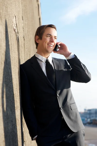 Businessman relaxing and talking on mobile phone outdoors — Stock Photo, Image