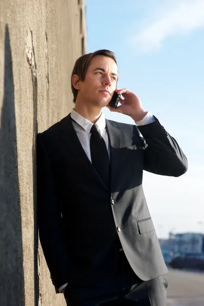 Atractivo hombre de negocios hablando en el teléfono celular al aire libre — Foto de Stock