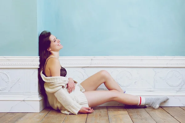 Donna sorridente seduta sul pavimento da sola con biancheria intima e maglione — Foto Stock