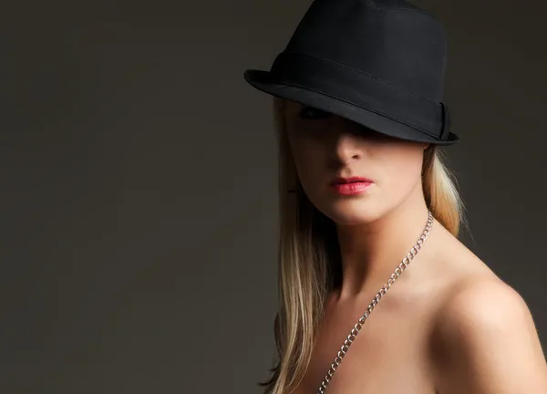 Porträtt av en ung blond kvinna klädd i svart hatt — Stockfoto