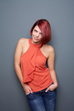 gri arka planı duran genç kadın