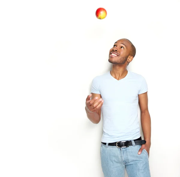 Здоровый молодой человек бросает яблоко в воздух — стоковое фото