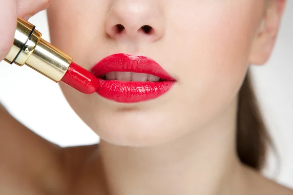 Bella giovane donna che applica rossetto rosso — Foto Stock